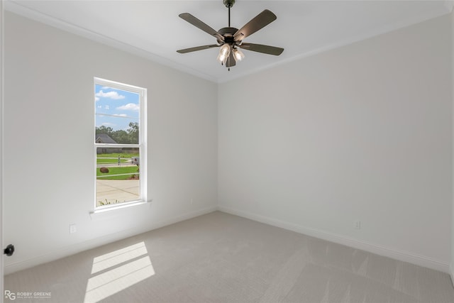 spare room featuring a ceiling fan, light colored carpet, and baseboards