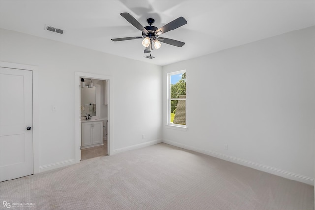 unfurnished bedroom with light colored carpet, visible vents, baseboards, and ensuite bathroom