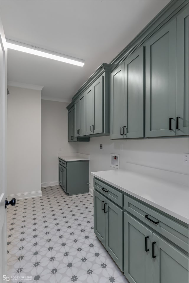 washroom featuring cabinets, washer hookup, crown molding, and light tile patterned flooring