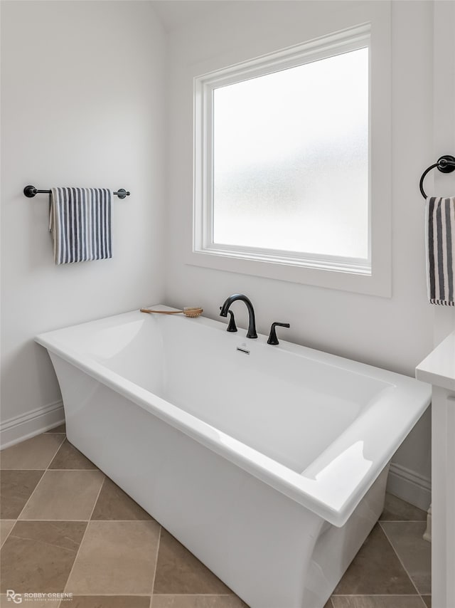 bathroom featuring a tub, tile patterned floors, and a healthy amount of sunlight