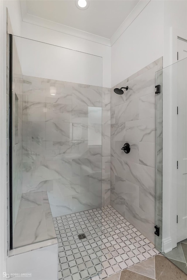 bathroom with a stall shower and crown molding