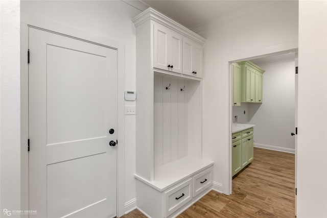 mudroom with ornamental molding and light wood-type flooring