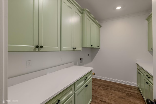 laundry area featuring cabinet space, dark wood-type flooring, ornamental molding, hookup for an electric dryer, and baseboards