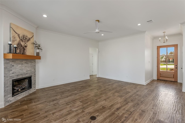 unfurnished living room with crown molding, a fireplace, wood finished floors, baseboards, and ceiling fan with notable chandelier