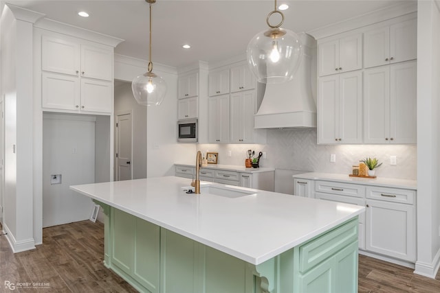 kitchen featuring tasteful backsplash, dark wood-style flooring, a sink, and built in microwave