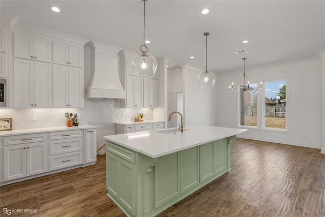 kitchen featuring premium range hood, a sink, green cabinetry, and white cabinetry