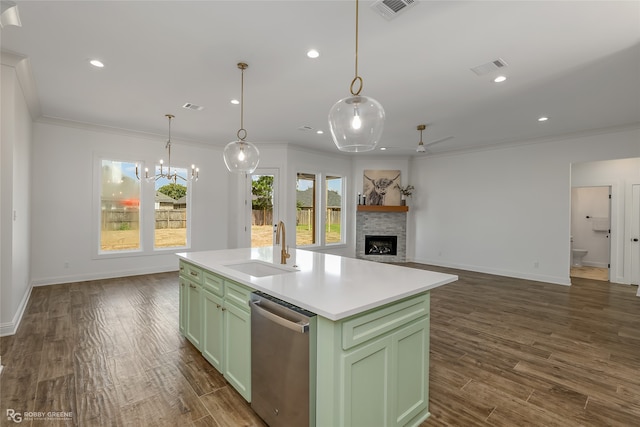 kitchen with stainless steel dishwasher, dark hardwood / wood-style flooring, sink, a stone fireplace, and a kitchen island with sink