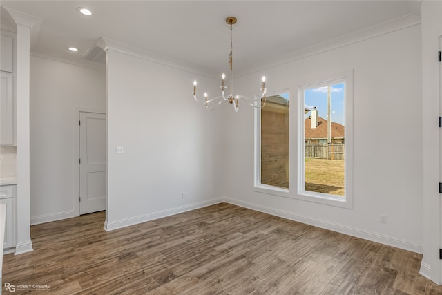 unfurnished dining area with plenty of natural light, wood-type flooring, and ornamental molding