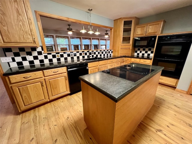 kitchen featuring pendant lighting, light hardwood / wood-style floors, ceiling fan, tasteful backsplash, and black appliances