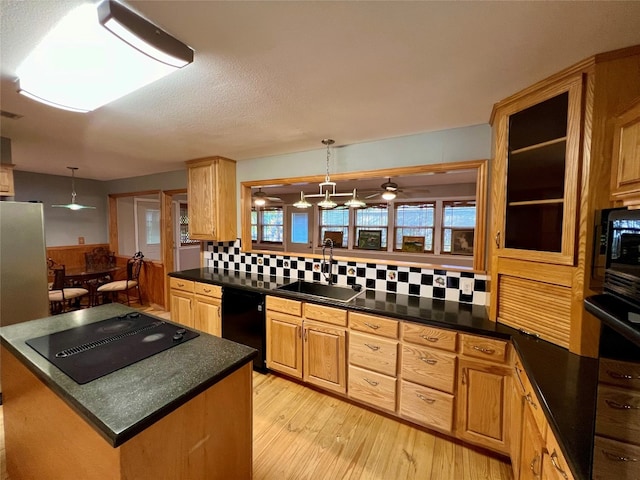 kitchen featuring tasteful backsplash, black appliances, pendant lighting, ceiling fan, and sink