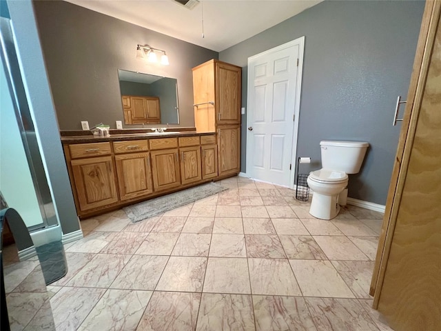 bathroom featuring toilet, tile floors, vanity, and a shower with door