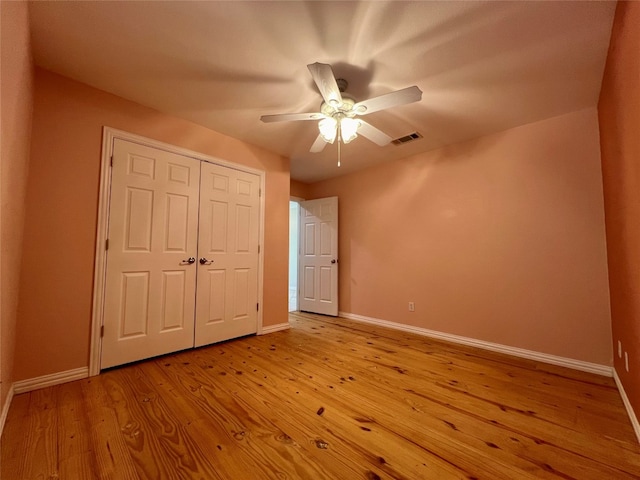 unfurnished bedroom with a closet, light hardwood / wood-style floors, and ceiling fan