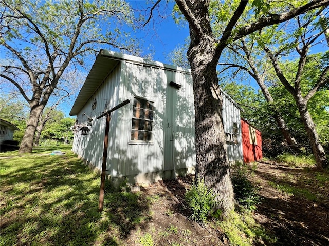 view of side of property with a lawn and an outdoor structure