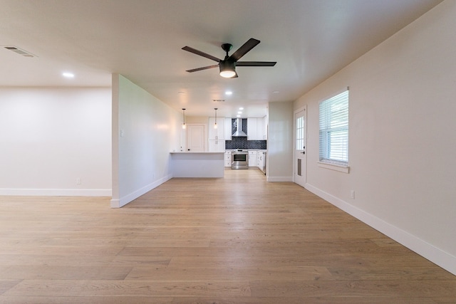 unfurnished living room featuring light hardwood / wood-style flooring and ceiling fan