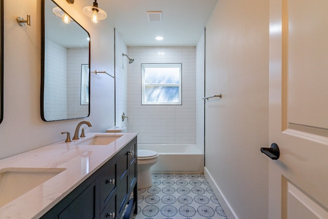 full bathroom with tiled shower / bath, toilet, dual vanity, and tile floors