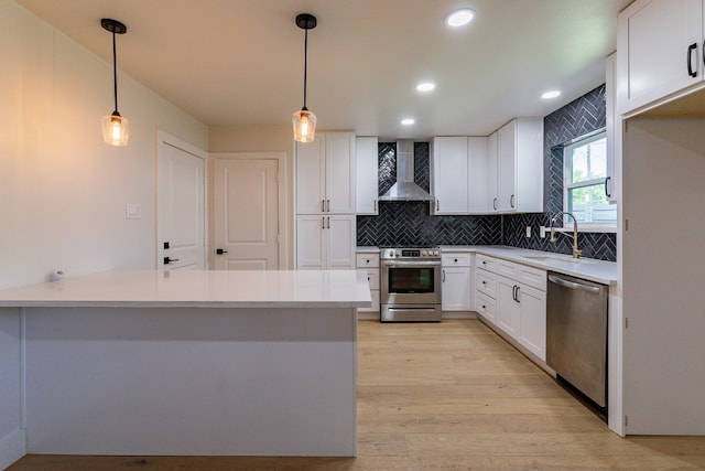 kitchen featuring light hardwood / wood-style flooring, wall chimney exhaust hood, tasteful backsplash, and stainless steel appliances