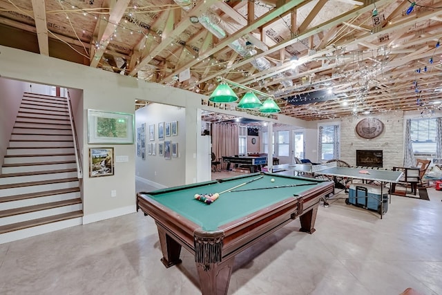 recreation room with brick wall, billiards, and a fireplace