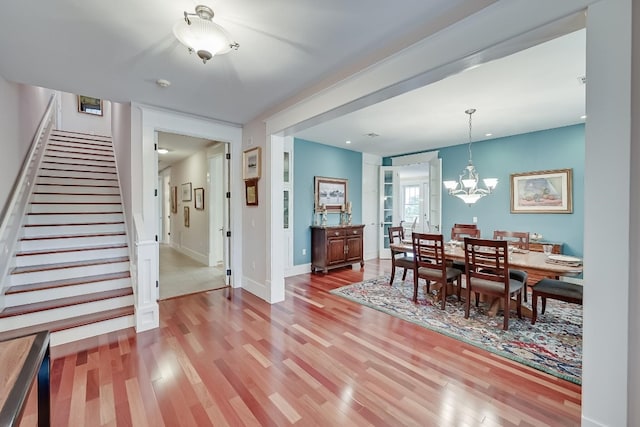 dining space with light hardwood / wood-style floors and a chandelier