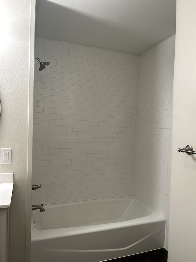 bathroom featuring vanity and tiled shower / bath