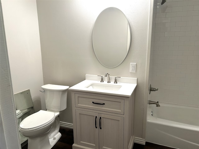 full bathroom featuring wood-type flooring, tiled shower / bath combo, toilet, and vanity