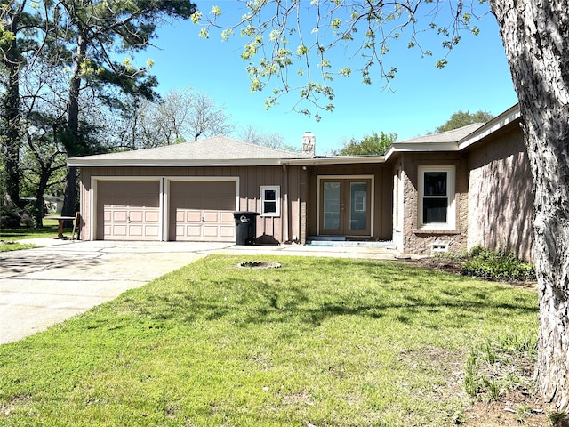 ranch-style house with a garage and a front lawn