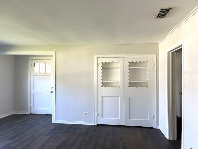 unfurnished bedroom featuring dark wood-type flooring and a closet