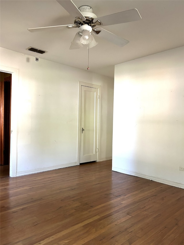 spare room with dark wood-type flooring and ceiling fan