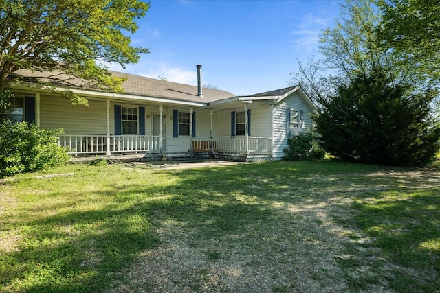 back of property with a yard and a porch