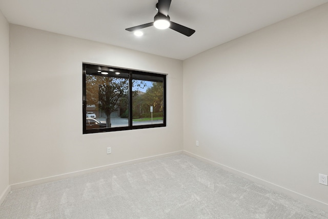 carpeted spare room featuring ceiling fan