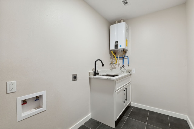 laundry room featuring sink, tankless water heater, hookup for an electric dryer, dark tile patterned floors, and hookup for a washing machine