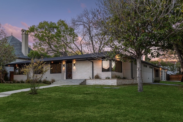 view of front of property featuring a garage and a yard