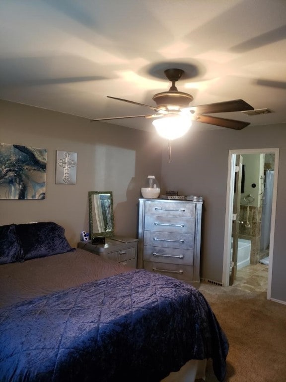 carpeted bedroom with ceiling fan and ensuite bathroom