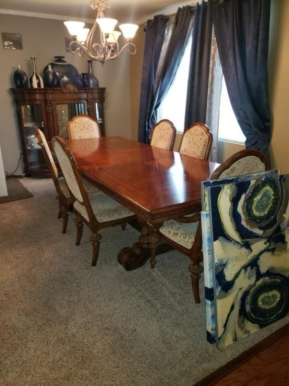 dining room featuring a notable chandelier and carpet