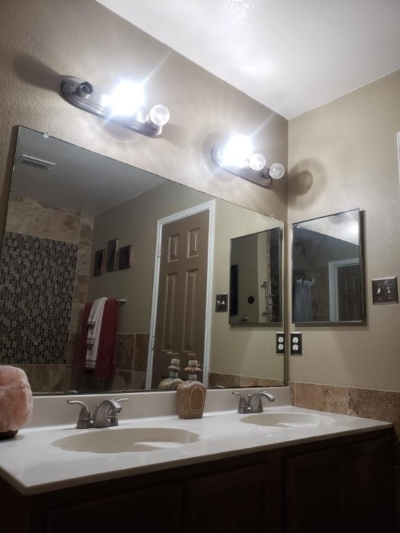 bathroom featuring vanity with extensive cabinet space and dual sinks