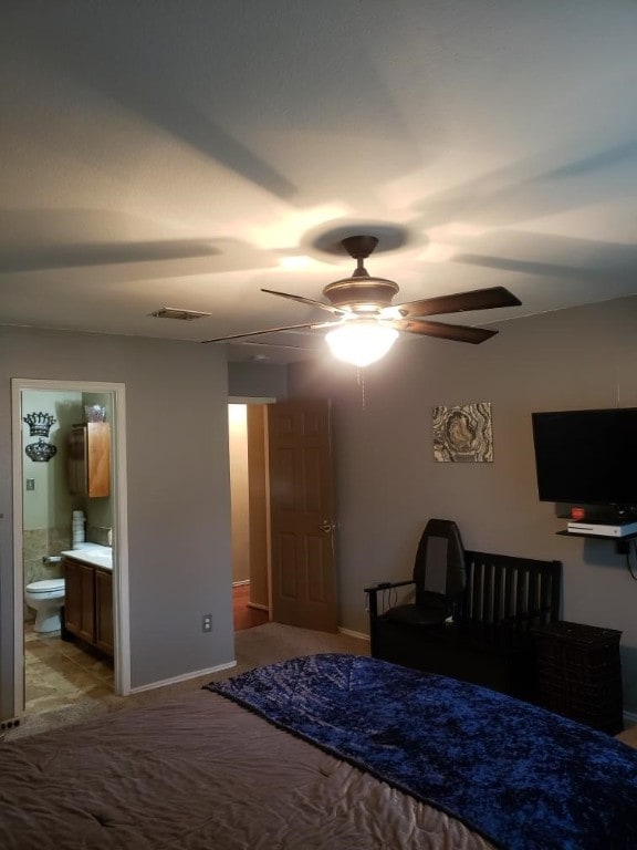 bedroom with ceiling fan, carpet flooring, and ensuite bathroom