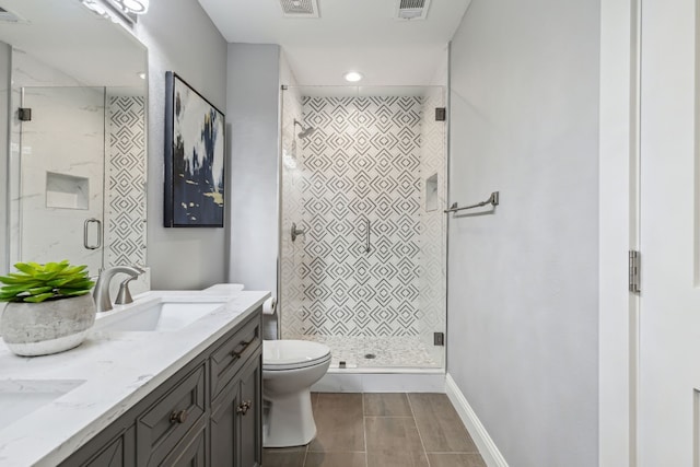 bathroom featuring toilet, tile patterned floors, a shower with door, and dual bowl vanity