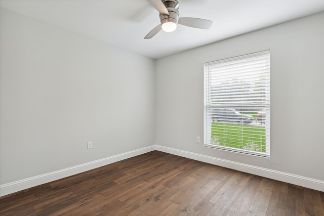 unfurnished room with a ceiling fan, dark wood finished floors, and baseboards