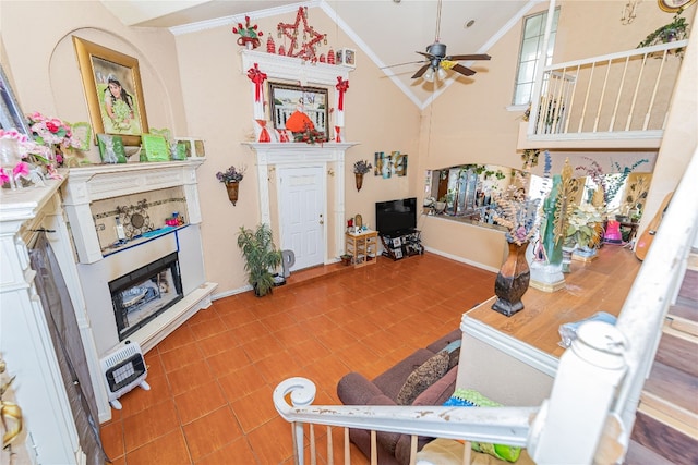 living room featuring tile flooring, crown molding, high vaulted ceiling, and ceiling fan