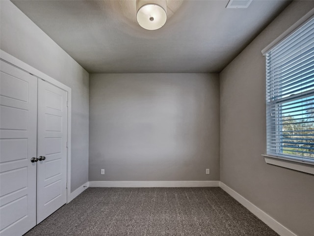 unfurnished room with dark colored carpet