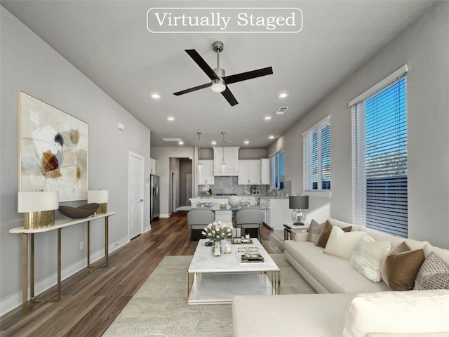 living room with ceiling fan, dark wood-type flooring, and sink