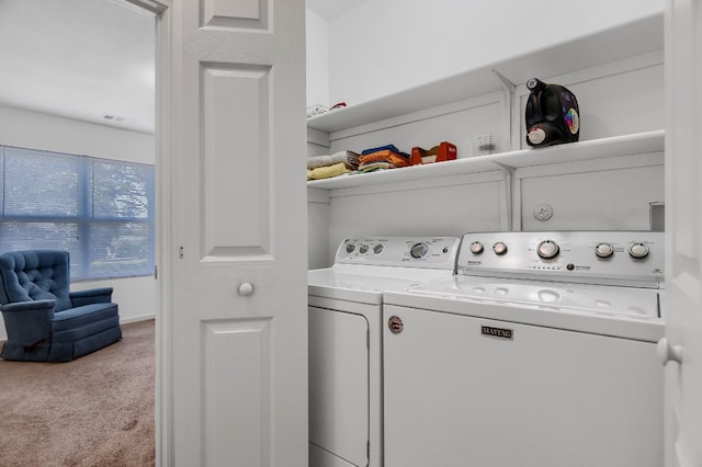 laundry room featuring washing machine and dryer and light colored carpet