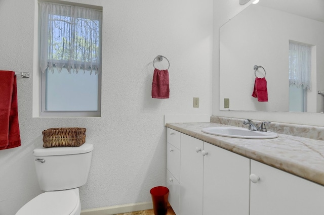 bathroom featuring toilet and vanity with extensive cabinet space