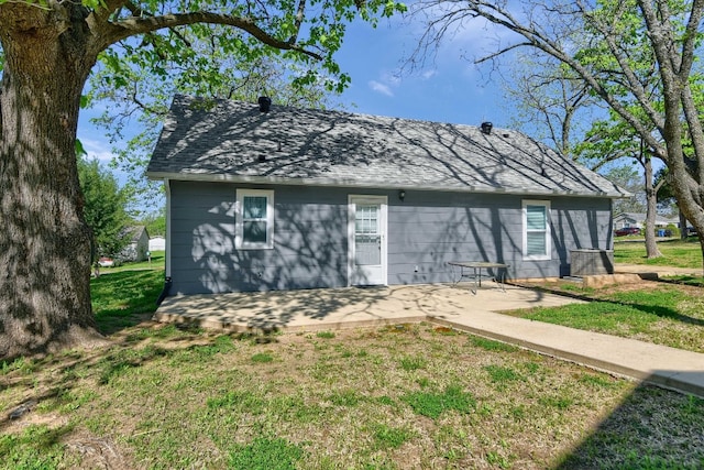 back of property with a yard and a patio area