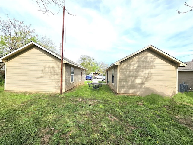 view of property exterior featuring central air condition unit and a lawn