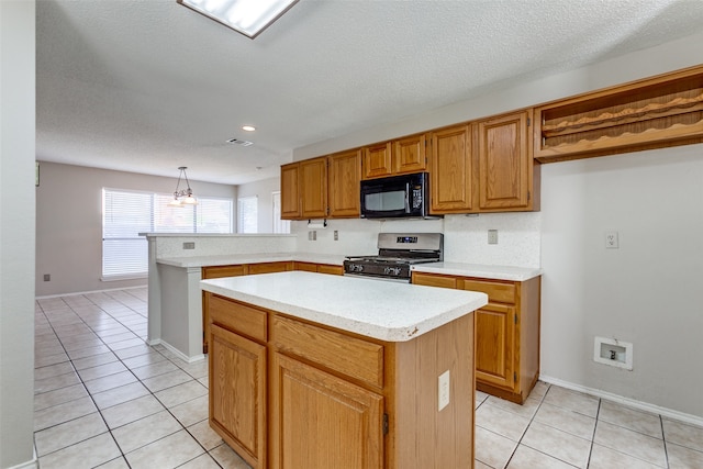 kitchen featuring a kitchen island, light tile patterned floors, pendant lighting, a textured ceiling, and gas range