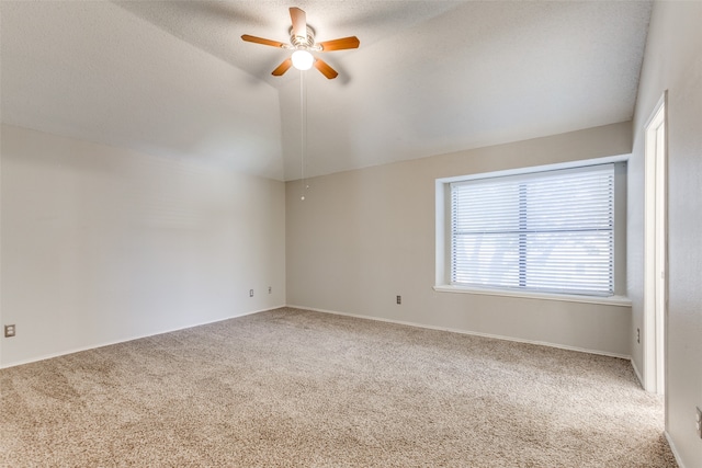 empty room featuring carpet floors, a textured ceiling, vaulted ceiling, and ceiling fan