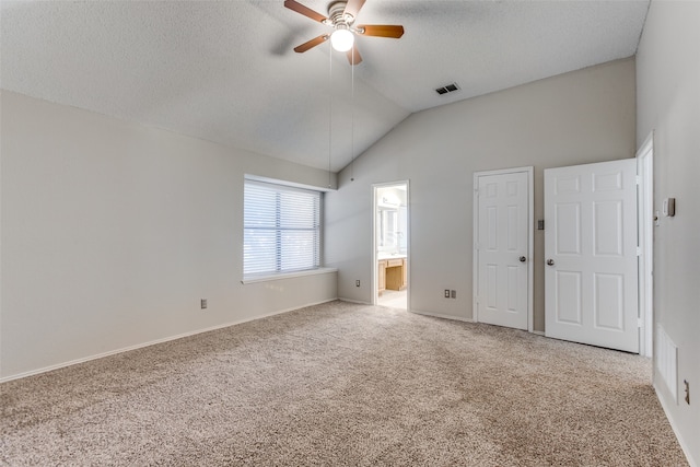 unfurnished bedroom with connected bathroom, carpet flooring, vaulted ceiling, and ceiling fan