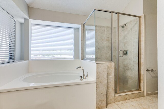 bathroom featuring a textured ceiling, plus walk in shower, and tile patterned flooring