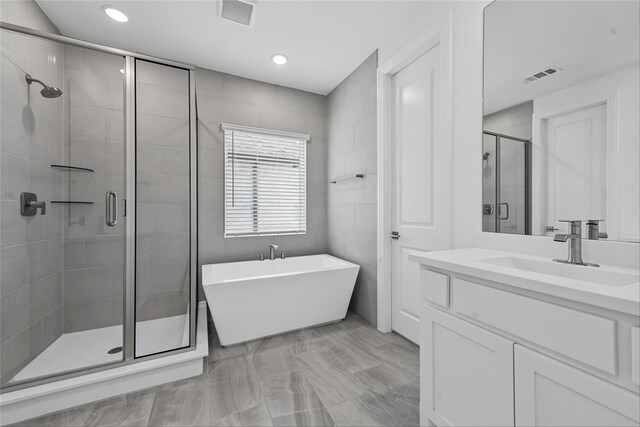 bathroom featuring vanity and separate shower and tub