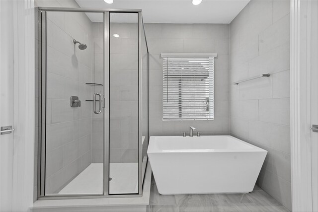 bathroom with independent shower and bath and tile walls